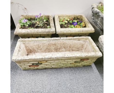 A pair of concrete garden planters together with a matching long concrete planter, 70 x 27 x 19cm.
