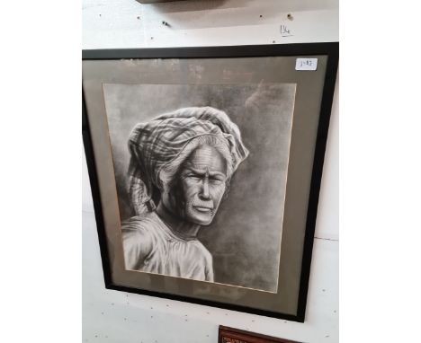 A charcoal portrait of a woman, framed and glazed. 