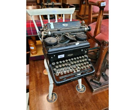 A vintage Royal typewriter and a white painted child's chair. 