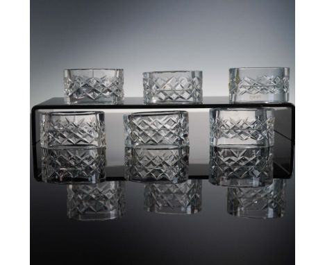 Set of six oval-cut glass napkin rings featuring cross-cut patterns and the etched Waterford mark. Two retain original foil l