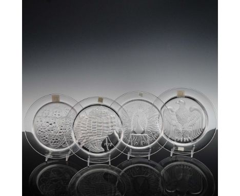A collection of four exquisite Lalique France crystal plates, each featuring a unique raised motif and signed "Lalique France