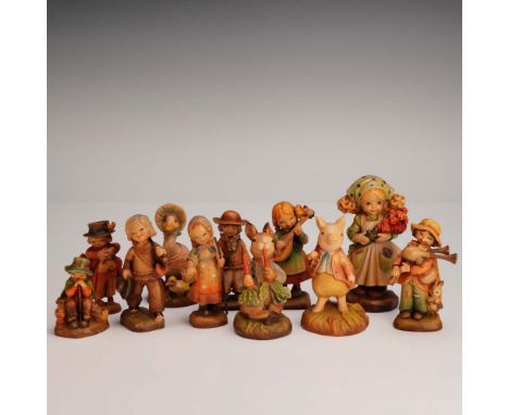 This charming 11-piece collection of hand-carved and hand-painted wood figurines is marked ANRI, with several bearing the F. 