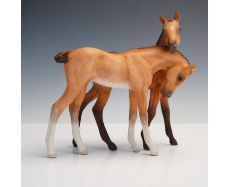 This endearing porcelain sculpture by Cybis features a pair of colts nuzzling affectionately, showcasing the American studio'