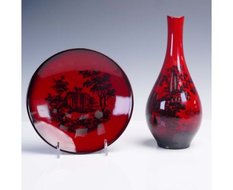 Set of two Royal Doulton flambe red glaze porcelain items including a small bottle-shaped vase and a circular plate. Both pie