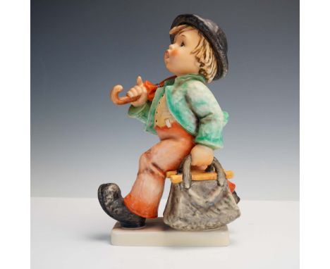 This classic Goebel Hummel figurine titled Merry Wanderer features a charming young boy in a green jacket and orange trousers