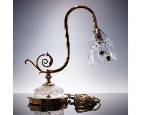 A crystal and brass desk lamp featuring a gracefully curved arm and cut crystal bell shade. The clear crystal base and shade 