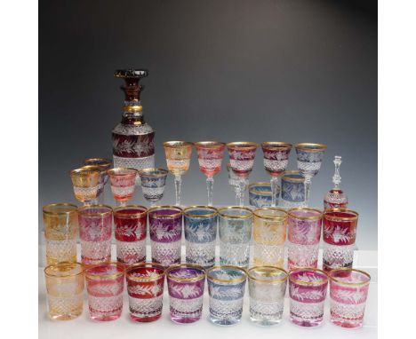 Vibrant 32-piece Bohemian crystal barware set featuring rich jewel-toned cut-to-clear glass with diamond-cut bases and etched