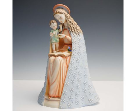 This Goebel porcelain figurine depicts a serene Madonna seated with the Christ Child standing on an open book, both engaged i