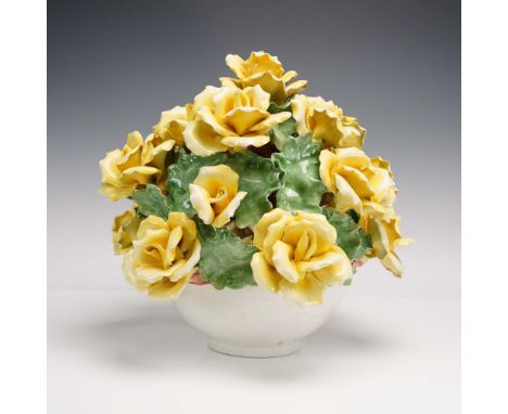 Handcrafted ceramic floral centerpiece featuring a vibrant bouquet of yellow roses with glossy green leaves arranged in a rou