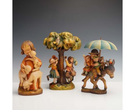 A charming trio of hand-carved wood figurines from the Anri Ferrandiz Collection, each vividly depicting nostalgic childhood 