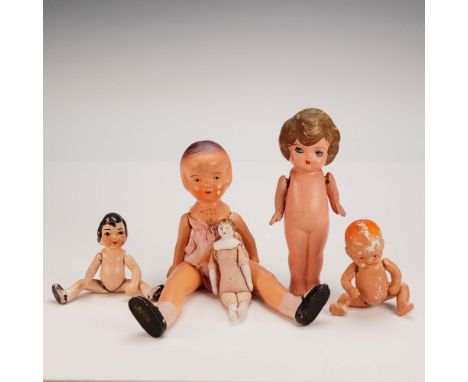 A nostalgic set of five pre-war bisque dolls, each displaying hand-painted details and jointed arms for gentle articulation. 