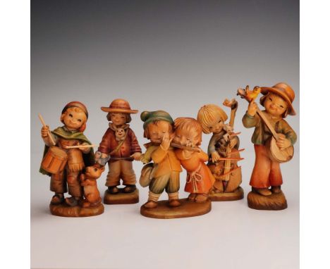 A delightful set of five hand-carved wooden figurines by Anri, renowned for its exquisite craftsmanship from Val Gardena, Ita
