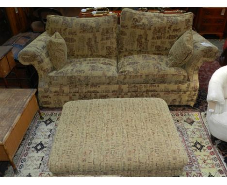 A two seater sofa, having Egyptian pattern on a sand coloured ground, together with matching cushions and footstool. H.95cm W