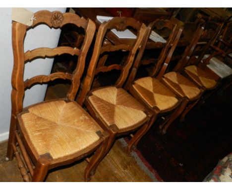 A set of eight oak carved ladder back dining chairs, with woven rush seats. 