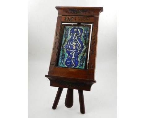 A Turkish ceramic tile, decorated with Arabic script on a blue and turqoise ground, set in an Egyptian easel. 