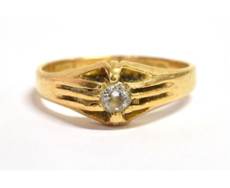 AN 18CT GOLD CLEAR PASTE SOLITAIRE RING The ring with textured shoulders on a tapered yellow gold band, hallmarked for Birmin