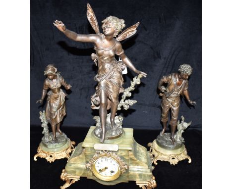 AN EDWARDIAN THREE PIECE FIGURAL SPELTER CLOCK GARNITURE the central clock with winged fairy 'Fee aux Fleurs' after Moreau, o