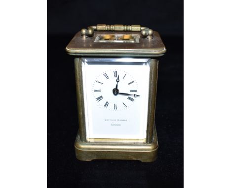 A BRASS CASED CARRIAGE CLOCK  the enamel dial inscribed 'MATTHEW NORMAN LONDON', 12cm high with carrying handle down Conditio