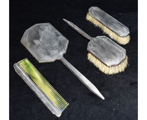 AN ART DECO SILVER DRESSING TABLE SET comprising a silver backed mirror 31cm in length, a silver backed hair brush, 24cm in l