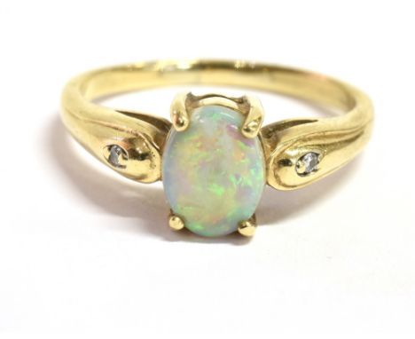 A 9CT GOLD OPAL DRESS RING The ring set with a single opal measuring 0.8cm X 0.6cm with a white sapphire accent each side, sm