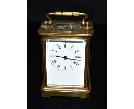 A BRASS CASED CARRIAGE CLOCK  the enamel dial with Roman numerals, 12cm high with carrying handle down Condition Report : wit