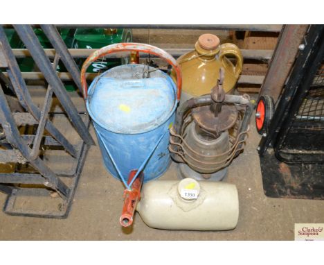 A painted galvanised watering can; a tilly lamp; stoneware bottle and a stoneware hot water bottle
