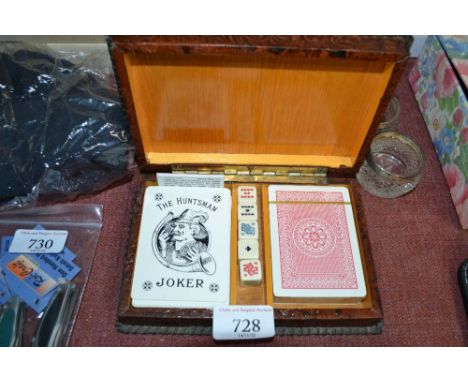 An embossed leather and wooden card box and contents of playing cards and poker dice