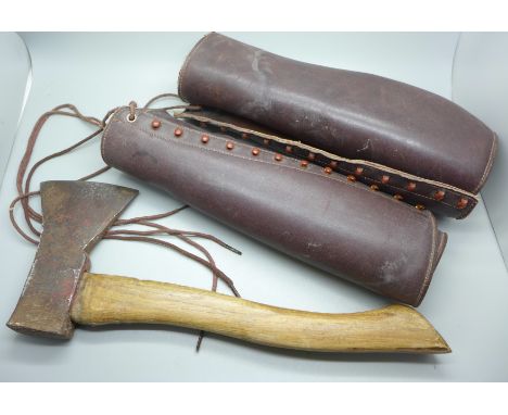 A WWII German soldier axe stamped with Gebr. Pandel makers mark and leg protectors 