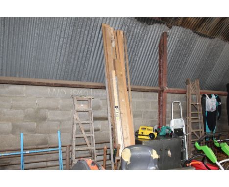 A quantity of timber some smooth planes and skirting panels together with a wooden ladder and various garden tools etc