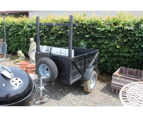 A black painted wooden and metal single axle car trailer with light board and spare wheel