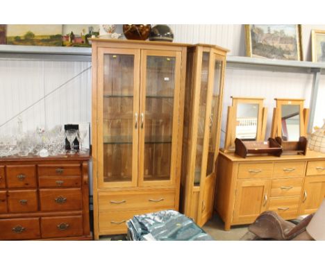 A light oak corner display cabinet together with a light oak two door display cabinet fitted two drawers below