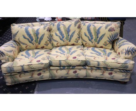 A mid 20th century curved three seat sofa upholstered with floral designs against a yellow ground. Not available for in-house