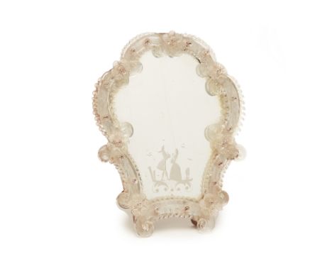 A VENETIAN GLASS TABLE MIRROR
Of cartouche shape with floral decoration, the mirror plate etched with a scene of a couple in 