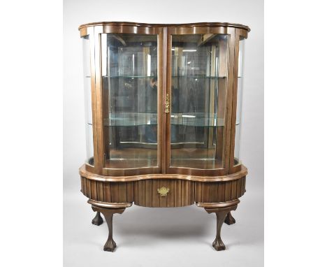 An Early/Mid Serpentine Front Glazed Display Cabinet with Mirror Back and Two Inner Glass Shelves, Base Drawers and Raised on