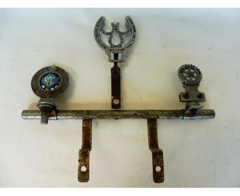 A short badge bar with two badges attached including Rotary International, also a horse shoe shaped car badge. 
