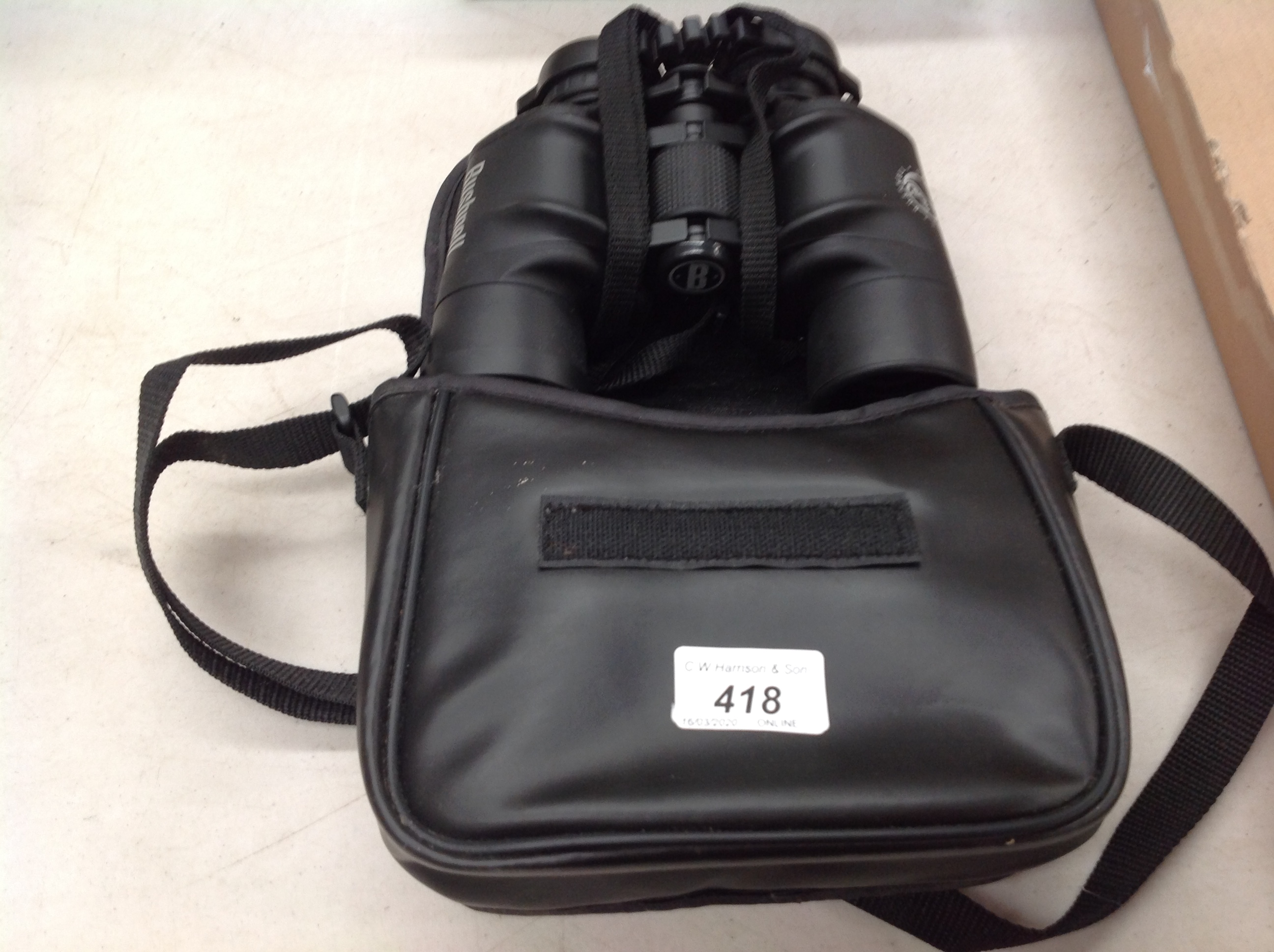 A pair of Bushnell 132010 10x42 binoculars in bag