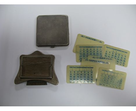 A Hallmarked Silver Mounted Desk Calendar, with date cards; together with a ladies powder compact, allover engine turned. (2)