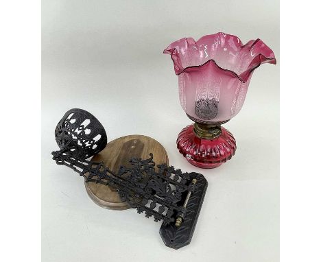 CRANBERRY GLASS WALL MOUNTED OIL LAMP with cranberry coloured reservoir and etched glass shade, together with a cast metal wa