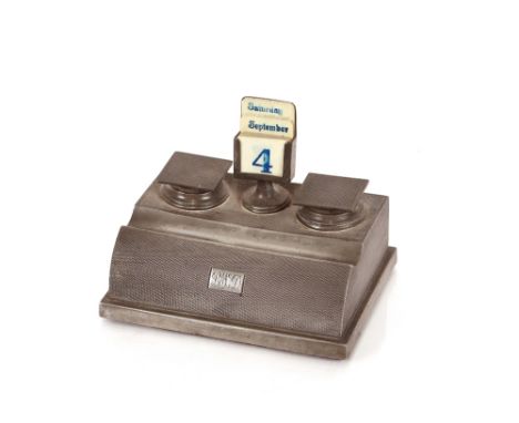 An antique pewter desk stand, having central calendar flanked by inkwells, engine turned decoration with monogrammed cartouch