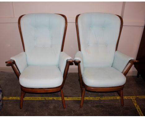 A pair of Ercol cottage style stick back wing armchairs