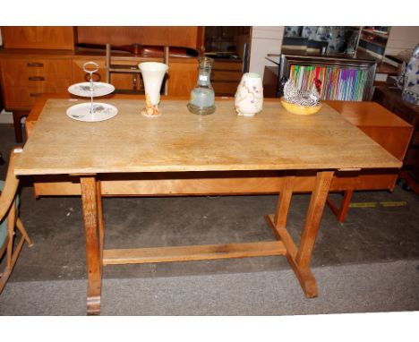 In the manner of Heals a light oak refectory style dining table, raised on square section supports and block ends, 152cm x 74