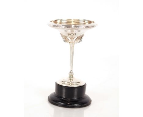 James Fenton, a silver tazza with wing decoration, tapering stem and spread foot, Birmingham 1930, raised on a black wood pli