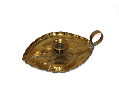 A brass Arts &amp; Crafts chamber stick with fish decoration