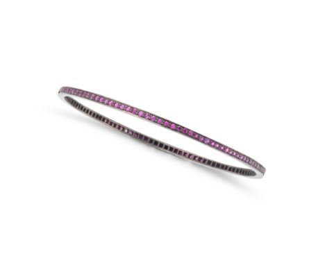 A RUBY BANGLE set all around with a row of round cut rubies, the rubies all totalling 2.7-2.9 carats, no assay marks, inner c