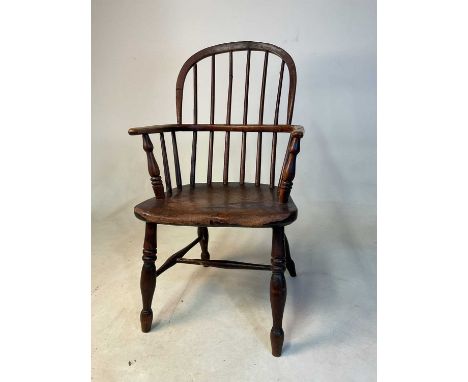 A 19th century child's ash and elm hoop back Windsor chair with saddle seat and ring turned front legs.