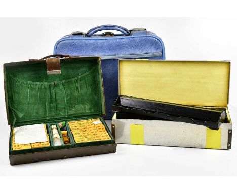 A vintage leather cased Mahjong set with metal container and blue suitcase.