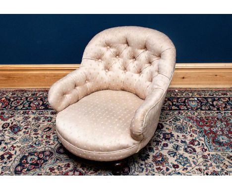 A 19th century nursing chair upholstered in a cream button back material.