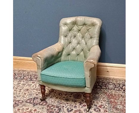 A 19th century leather button back tub chair, on turned column supports terminating on brass castors.