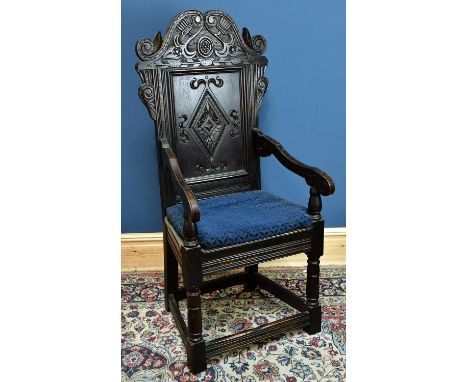 A carved oak wainscot type chair, with panelled seat on block feet.