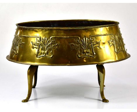 An Arts and Crafts brass planter of shaped oval form with embossed floral decoration, length 45cm, together with a brass triv